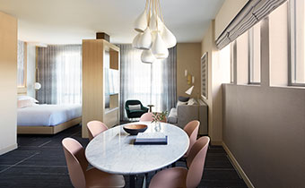 Hollywood Suite dining area with view of bedroom at Kimpton Hotel Wilshire